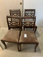 Four vintage wooden dining chairs arranged in two rows, showing overall condition and upholstery wear.