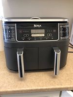 Front view of Ninja Dual Zone Air Fryer showing control panel and dual drawers with handles closed on countertop.
