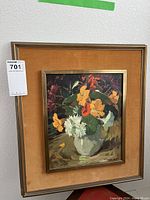Full view of framed oil painting showing vibrant floral bouquet in white vase with gold frame and tan fabric mat.