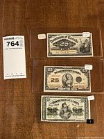 Overview of three notes in clear sleeves laid on wood surface