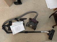 Samsung 1300W vacuum cleaner with hose, wand, floor nozzle, vacuum bags on beige carpet