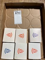 Six square white boxes with Canada crest logos arranged in cardboard box