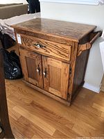 Front and angled view showing drawer, cabinet doors, and wood grain finish.