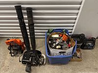 Photo of the overall lot with blower tubes, motor assembly, containers of parts, and generator.