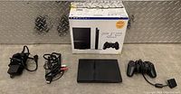 Full bundle with console, controller, power adapter, AV cable and box on metal surface