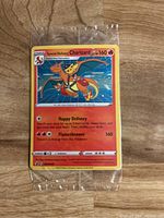 Photo of sealed Special Delivery Charizard Pokémon card with visible card details.