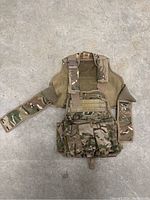 Full view of Tiberius camouflage tactical vest laid flat showing front pouches and straps.
