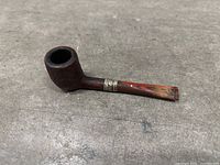 Full side view of rusticated briar pipe with silver band and red stem