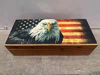 Front view of wooden box showing painted lid with American flag and bald eagle design.