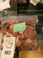 Clear resealable plastic bag full of U.S. pennies labeled with 4 lbs note and auction tag 663.