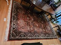 Full view of rug under dining table showing overall pattern and wear