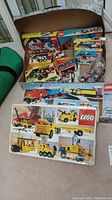 Vintage LEGO boxes showing bright yellow vehicles with wheels and mechanical parts on packaging