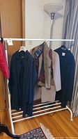 Full view of white metal rack holding five garments
