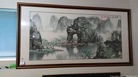 Full view of the framed Chinese landscape painting showing mountains, river, trees and houses