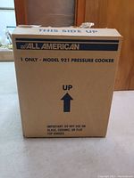 Sealed cardboard shipping box labeled All American, Model 921 Pressure Cooker