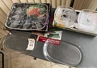 Photo showing 4 dessert plates stacked in original packaging, 1 rectangular serving platter, and 2 matching glass platters on table