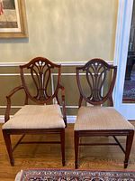 Two chairs, one side chair and one armchair, front view showing harp-style open backs and beige velour seats