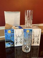 Two original boxes of Cristallo Italiano 24% lead crystal tall tumblers and two tall crystal glasses placed on top and in front of boxes.