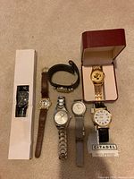 Photo showing seven wristwatches in various styles and bands, some in boxes, including Disney Mickey Mouse and Citadel brands.