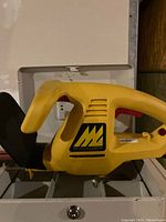 Yellow McCulloch branded hedge trimmer showing side profile of handle and blade guard.