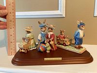 Full view of the three Bunnykins figurines assembled on wooden base with plaque