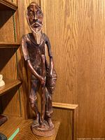 Front view of the wooden carved figure of a man showing full height and detail.