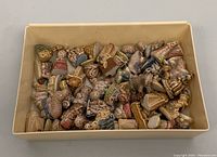 Top view of more than 25 assorted WADE porcelain miniature figurines in a box, showing various animals and human characters with glazed finish.