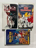 Photo showing three Disney VHS tapes including 102 Dalmatians, 101 Dalmatians, and Oliver & Company in their original cases.