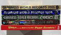 Spines of five hardcover books showing four Guinness World Records editions (2002, 2004, 2005, 2011) and one Ripley's Believe It or Not! Planet Eccentric! book.