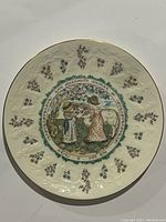 Front view of Royal Doulton plate showing classic Kate Greenaway style illustration of two children and floral decorative border with gold rim.