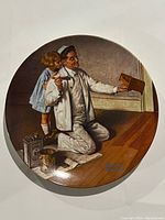 Front view of the Norman Rockwell "The Painter" collector plate showing the painted scene of a painter and child.