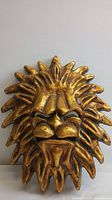 Front view of gold leaf cast resin lion face wall mask showing full piece and textured mane.