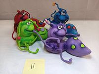 Front angled view showing all four colorful rubber composite ant sculptures grouped together on a plain background.