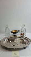 Full set displaying silverplate tray holding trinket box and candle holders, two glass decanters, and glass pitcher with animal image.