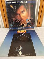 Front cover of 'Elvis Presley: 1954-1961' album and front cover of 'Elvis Moody Blue' album showing artwork and condition.