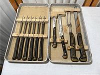 Full view of the cutting tool set with all pieces in fabric-lined case, showing 8 steak knives and 4 larger cutting tools with wood handles.