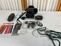 View of the entire lot showing monocular, compass, lens cleaning tools, and other small accessories.