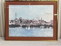Full view of the framed coastal cityscape artwork showing the city skyline, water, and sailboats.