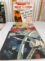 Orson Welles War of the Worlds vinyl record cover in orange and white with vintage newspaper style design.