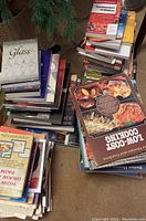 Photo showing multiple stacks of varied used books including cookbooks and art books