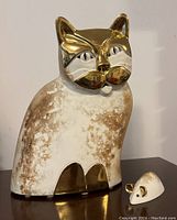 Photo of ceramic cat and mouse figurines with gold accent details from a front angle showing overall size and style.