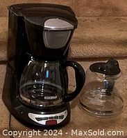 Photo of Black and Decker drip coffee maker with one glass carafe on the machine and an additional spare glass carafe beside it.