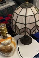 Two lamps on table, showing stained glass shade and ceramic base with worn electrical cord