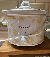 Front view of Crock-Pot slow cooker with yellow floral design and rotary switch.