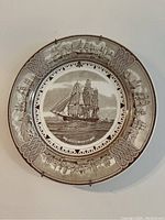 Front view of the Wedgwood Flying Cloud decorative plate in sepia tones with maritime border design and hanger.