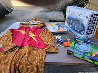 Full lot on table including costume, spinners, Nerf target, and planetarium projector box