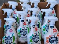 Photo showing multiple Family Guard disinfectant spray cleaner bottles in a cardboard box.