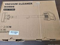 Box showing line drawing of TC1-Mate vacuum cleaner stick with model number on cardboard packaging.
