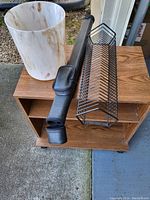 All items on and around the TV cart: TV cart, pool stick case, CD holder, and trash can