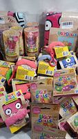 Multiple new Ugly Dolls items including plush keychains, surprise toy bags, collectible figures in tubes, and blanket throws displayed together